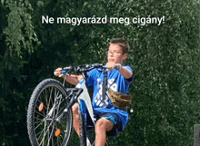 a boy in a blue shirt is riding a bike with the words ne magarzad meg cigany written above him