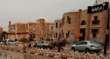 a row of cars are parked in front of a large building with arabic writing on it