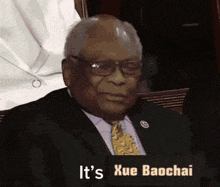 a man in a suit and tie is holding a sign that says it 's xue baochai