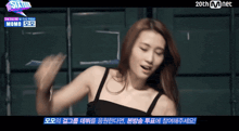 a woman in a black top is dancing in front of a sign that says sixteen