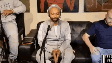 a man wearing headphones is sitting in front of a microphone in a room .