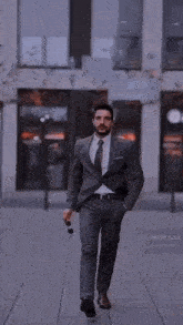 a man in a suit is tying his shoelaces .