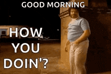 a man is standing in front of a building and asking how you doin ' ?