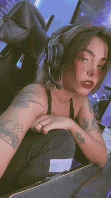 a woman wearing headphones and a ring on her finger is sitting in a chair