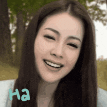 a woman with long hair is smiling with the word ha written below her