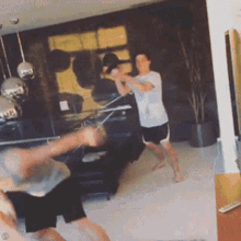 two men are playing a game in a living room with a remote control