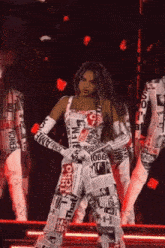 a woman is standing on a stage wearing a newspaper jumpsuit .