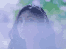 a close up of a woman 's face with a purple smoke coming out of it .