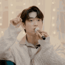 a young man is singing into a microphone while making a funny face