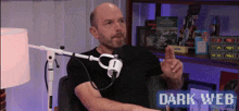 a man is sitting in front of a microphone with the words dark web on the bottom right