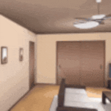 a blurry picture of a living room with a couch , table , and ceiling fan .