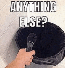 a person is holding a microphone in front of a trash can that says anything else ?
