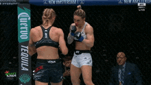 two women are fighting in a cage with a banner that says tequila