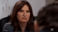 a woman is sitting in a chair and looking at another person .