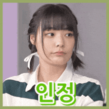 a girl with pigtails is wearing a green and white striped shirt with chinese writing on it .