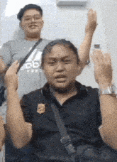 a man and a woman are standing next to each other with their hands up .