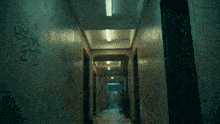 a person walking down a hallway with graffiti on the wall