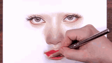 a person drawing a woman 's face with a pencil
