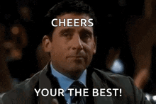 a man in a suit and tie is holding a glass of whiskey and toasting with the words cheers your the best .