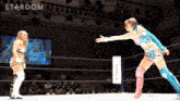 two women are wrestling in a ring with a sign that says softbank