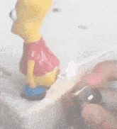 a bart simpson figurine is standing on a counter top with his butt sticking out .