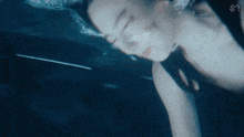a woman is swimming underwater with the letter s on the bottom right