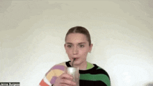 a woman is drinking through a straw from a glass .