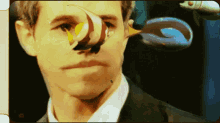 a close up of a man 's face with a fish on his nose