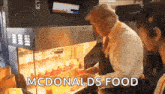 a man is standing in front of a mcdonald 's food display