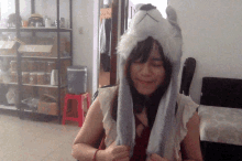 a woman wearing a wolf hat is smiling in front of a water cooler