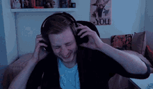 a man wearing headphones is sitting in front of a poster that says you