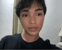 a close up of a person 's face with a black shirt