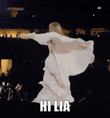 a woman in a white dress with wings is dancing with the words hi lia in the corner
