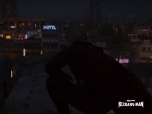 a man in a red cape stands in front of a building that says keluarga man on it