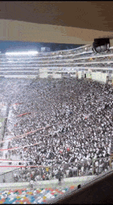 a large crowd of people are in a stadium watching a game .