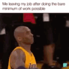 a bald man in a yellow jersey is standing on a basketball court looking up .