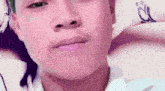 a close up of a young man 's face with a pink hat on .
