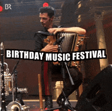 a man playing an accordion in front of a birthday music festival banner