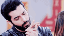 a man with a beard is holding a woman 's hand