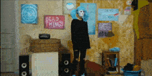 a girl in a room with a sign that says dead things on it