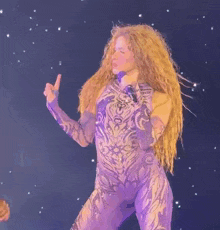 a woman in a purple bodysuit is giving the thumbs up sign