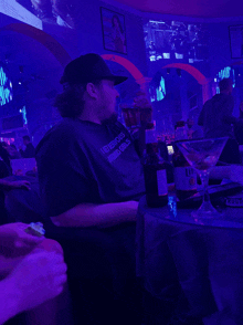 a man wearing a t-shirt that says i love boys and girls sits at a table