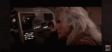 a video of a man looking through a machine that says ' a ' on the bottom right