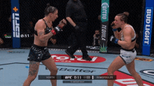 two women are fighting in a boxing ring with ads for corona and bud light in the background