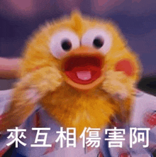 a yellow stuffed animal with chinese writing on it is being held in someone 's arms .