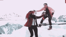 a woman in a red jacket is throwing a snowball at another woman