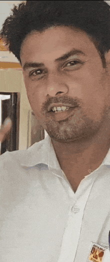 a man in a white shirt has a name tag that says ' aditya ' on it