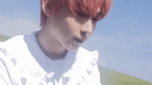 a close up of a person with red hair wearing a white dress .
