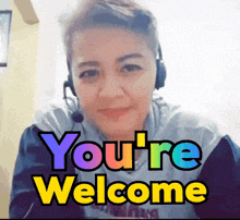 a woman wearing headphones says " you 're welcome " while smiling