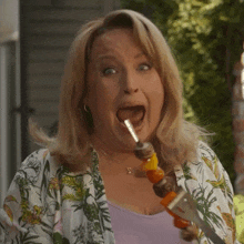 a woman in a floral shirt is making a surprised face